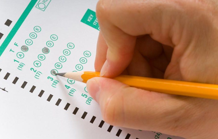A person wih a yellow pencil taking a multiple choice test or exam