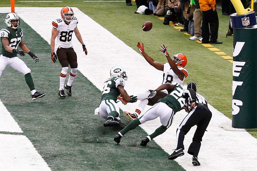 NEW YORK-DEC 22:  Cleveland Browns wide receiver Greg Little (18) leaps as New York Jets defensive back Aaron Berry (22) and safety Dawan Landry (26) defend during the first half at MetLife Stadium.