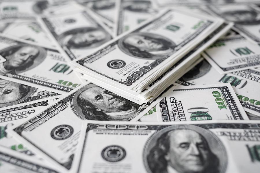 A stack of money. Heap of one hundred dollar bills on money background. Fake money. Shallow depth of field. Selective focus. Photo purchased from Bigstock.com.