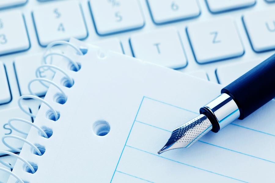 A notepad and keyboard of a computer. Write down and save.