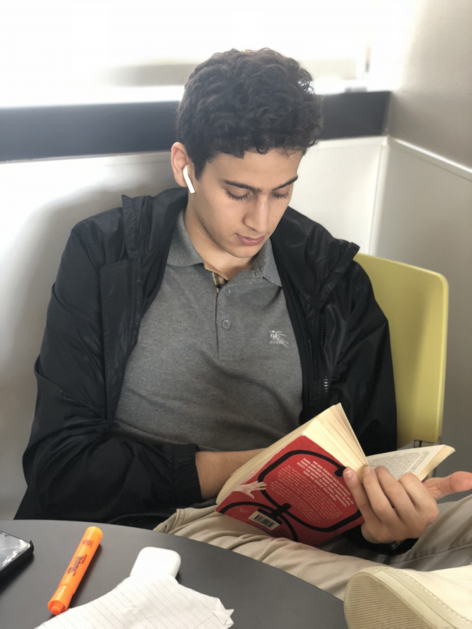 Ahmad Faisal ’20 reads a novel for English class. Photo By Sita Alomran ‘19.