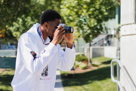 Gianni Thompson ’21 composes a shot using a DSLR camera in Photography class.