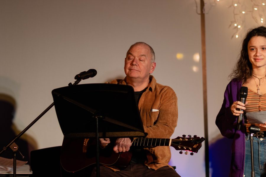 Creative Arts Department Chair Bill Jacob plays guitar as Anja Westhues 19 sings during the 2019 Coffee House. 