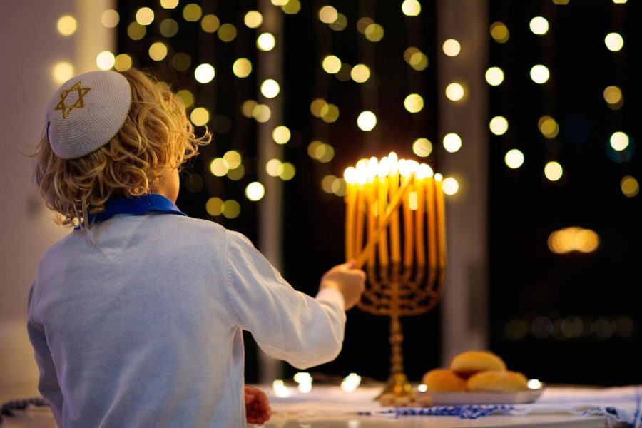 Photo+illustration+of+children+lighting+candles+on+traditional+menorah+purchased+at+BigStock.com