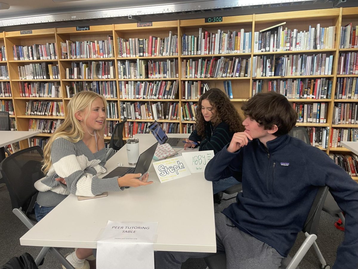 Stephanie Altschul '25, Eli Lewis '25, and Abigail Jacobs '25 gather at a designated peer tutoring table to review material. 