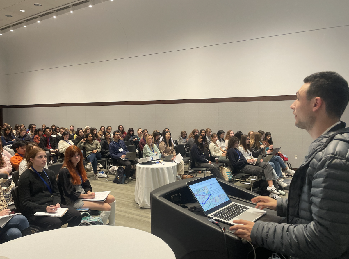 Co-Executive Editor Evan Michaeli '24 presents about effective opinion writing in front of a huge room. 