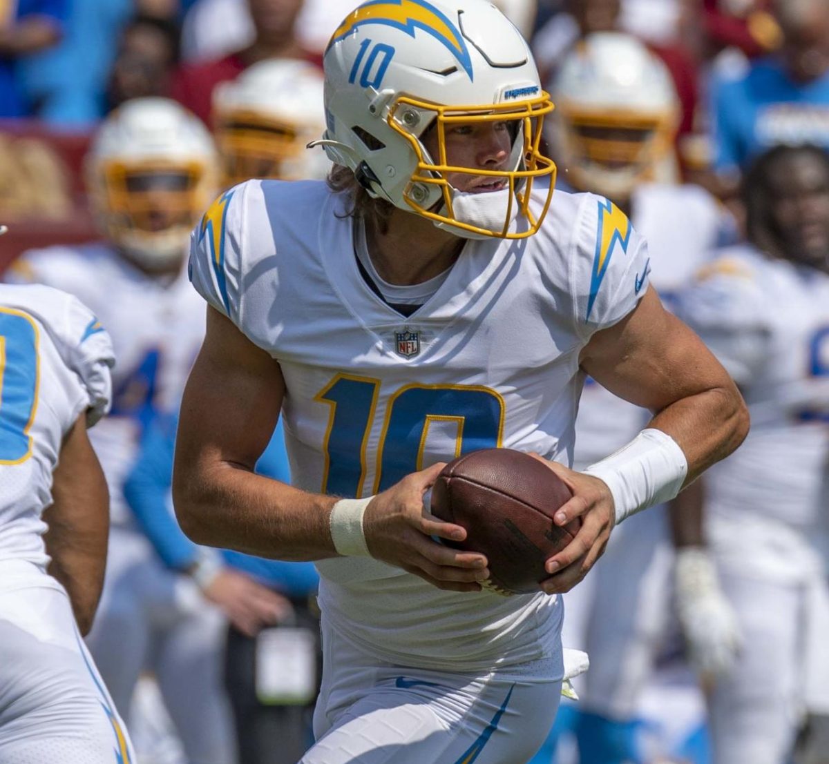 Los Angeles Chargers quarterback Justin Herbert runs with the ball against the Washington Commanders. Herbert has one of the strongest arms in the league, often throwing for several hundred yards a game. Herbert broke his finger in Week Fourteen. 
