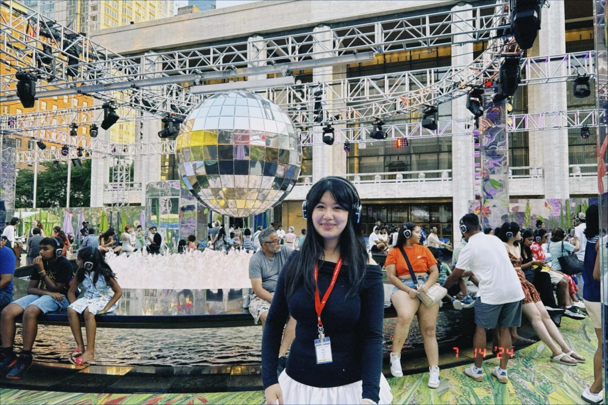 Mary Wang, with her New York Times press lanyard, relaxing with friends at a silent disco during the program.