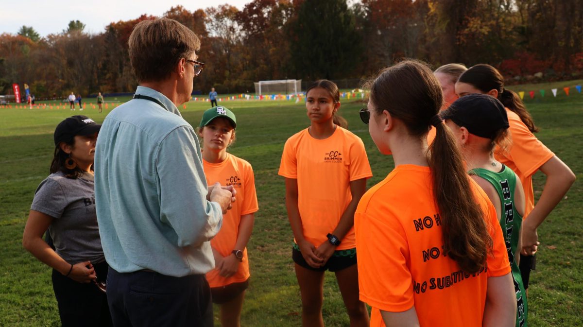 Coach Ted Barker-Hook gives the team a pep talk before a race.