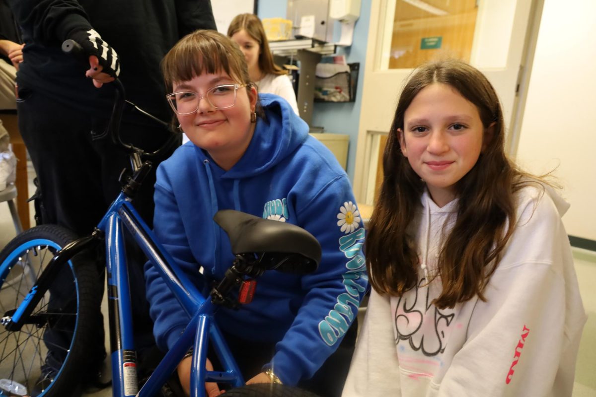 Ady Jaeckel '25 builds a bicycle with a middle school student.