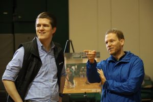 English teacher Bradley Star and Administrative Associate Mark Sehnert enjoy some looking at photos of the gym and its use over the decades. 