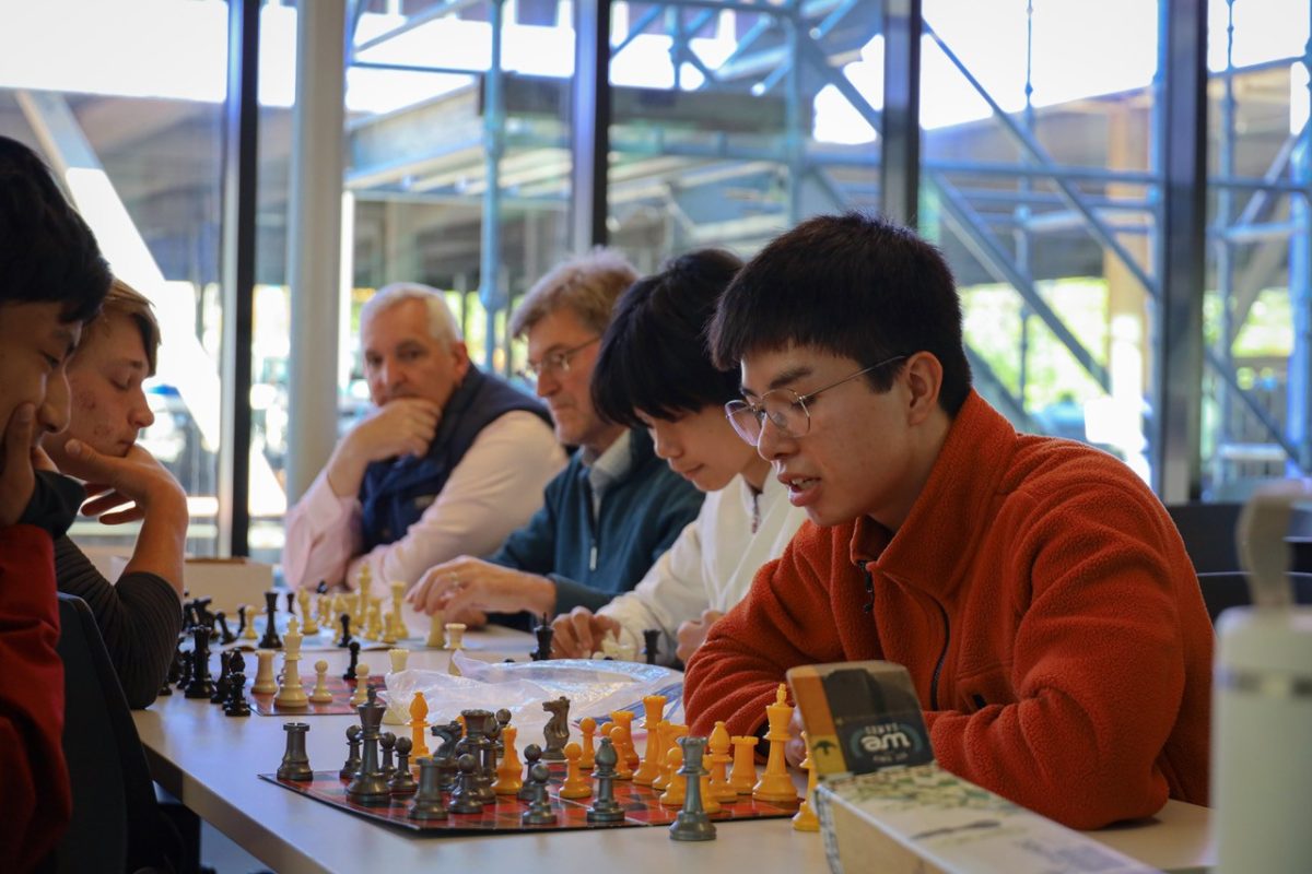 Sebastien Velastegui '26 plays chess with Ricky Thurmond '30 while Head of upper school Joshua Nuedel looks on.