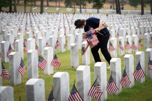 May 23, 2026, Canton, Georgia, USA: A volunteer helps place U.S. flags on veterans' graves during Memorial Day celebration at the Georgia National Cemetery. (Credit Image: © Robin Rayne/ZUMA Press Wire)
